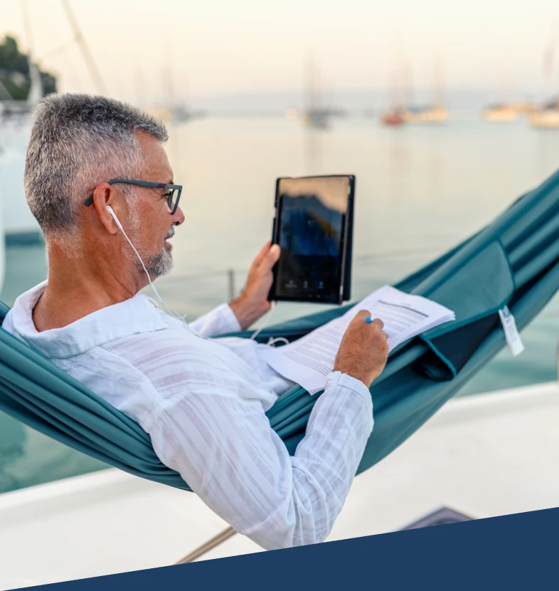 Individual working on tablet by the sea